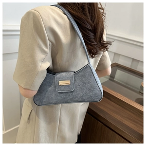 Detail view of gray felt baguette shoulder bag with rectangular gold metal plaque