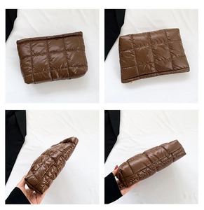 Detail view of the deep brown quilted puffer clutch bag with modern square stitching