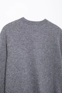 Close-up of the grey round neck knit cardigan showing the fabric texture and shoulder seams