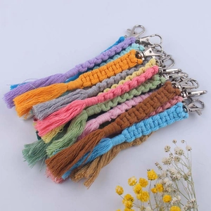Handmade woven cotton rope keychain with metal lobster clasp and tassels on white background