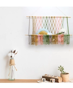 Détail du filet de rangement mural coloré en macramé avec tiges en bois et franges