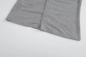 Detailed macro view of metal snap buttons on grey marl knit cardigan hemline