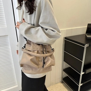Détail du sac seau kaki avec cordon de serrage, bandoulière réglable et boucles en métal