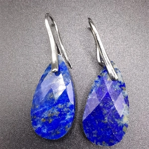 Macro view of teardrop faceted lapis lazuli earrings with silver hook details