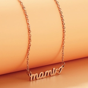 Detailed close-up of rose gold MAMA necklace with heart pendant on orange background