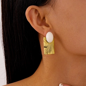 Vue latérale de boucles d'oreilles vintage en acrylique marbre jaune de forme carrée