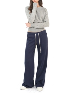 Gray crewneck long sleeve wool knit sweater paired with navy wide-leg drawstring pants
