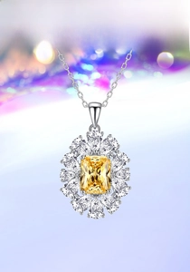 Macro shot of silver necklace with emerald-cut yellow stone and pear-shaped diamonds