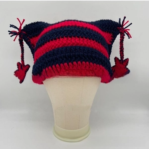 Macro shot of striped cat ear knit hat featuring tassels and star-shaped crochet charms