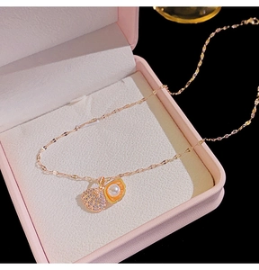 Detail of rose gold seashell necklace with pearls and zircons in a pink jewelry box