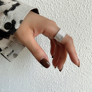 Detail of wide 925 sterling silver ring featuring a textured woven mesh design on a model