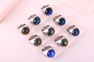 Macro detail of ten colorful dome rings featuring galaxy glass stones and silver bands