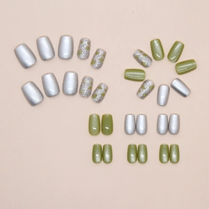 Flat lay of green cat eye press-on nails with silver glitter and heart patterns