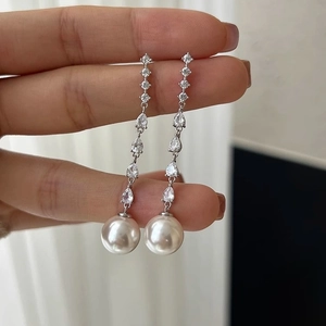 Elegant long drop earrings with white pearls and sparkling zircons in silver finish