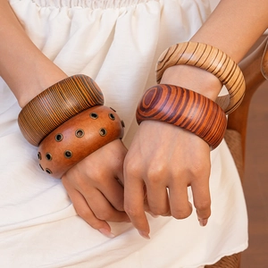 Close-up of bohemian wooden bangles with natural grain and metal rivet details