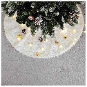 Detail view of a white faux fur Christmas tree skirt with warm glowing LED lights