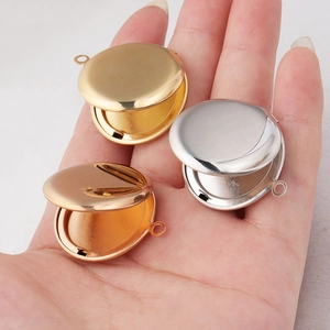 Three open circular locket pendants in gold, silver, and rose gold on a hand