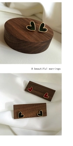 Macro detail of vintage heart earrings with dark green enamel and golden metal edges