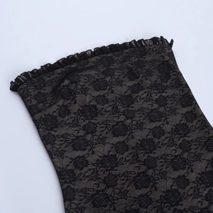 Détail du tissu en dentelle florale noire avec bords à volants et doublure en maille beige