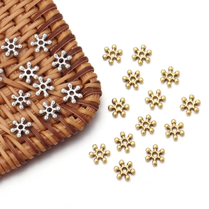Detailed macro view of 7mm vintage gold and silver snowflake spacer beads for jewelry