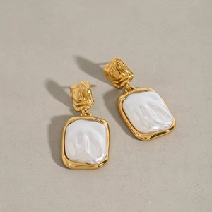 Detailed view of rectangular gold-plated earrings with white mother-of-pearl inlays