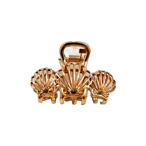 Detailed close-up of a golden metal claw clip featuring a unique three-shell design