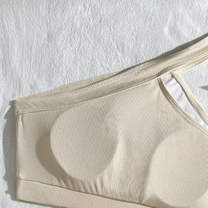 Detail of ribbed beige bikini top featuring built-in padding and high-quality texture