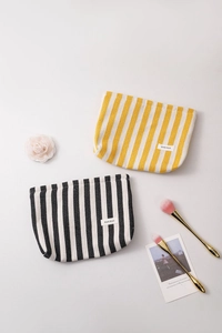 Close-up of striped canvas cosmetic bags with H&R brand label and durable zipper detail