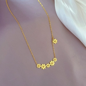 Detailaufnahme goldener Gänseblümchen-Anhänger an einer feinen Titanstahlkette