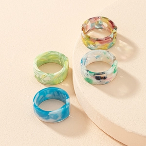 Close-up of retro colorful resin rings with marble texture on beige display stands