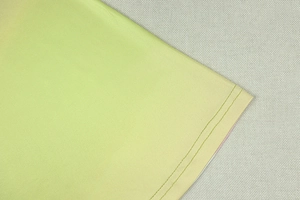 Dettaglio ravvicinato della doppia cucitura e trama in maglia fine su abito verde lime