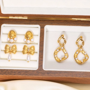 Classic 18k gold plated stainless steel bow and pearl earrings set in a wooden display box