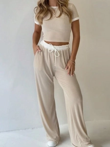 Women's two-piece knit set featuring short sleeve crop top and wide leg pants in beige