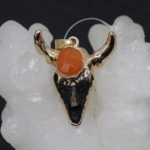 Golden bull skull pendant with faceted orange gemstone on white crystal base