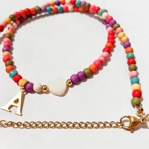 Colorful beaded necklace with white heart bead and gold letter A pendant for women