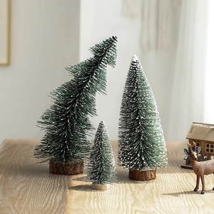 Three mini snow-flocked Christmas trees with wooden bases for festive tabletop decoration