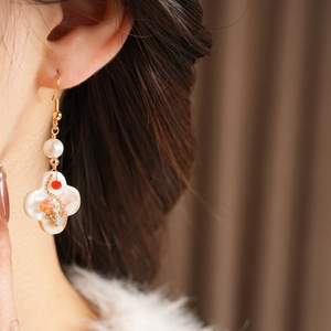 Detail of vintage clover earring featuring white nacre and pearl on the earlobe