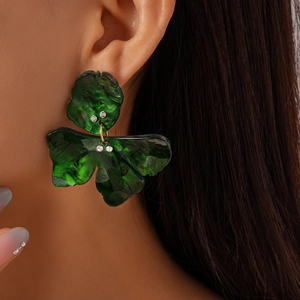 Close-up of a green marble resin leaf earring with sparkling rhinestones on model