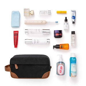 Detailed view of a vintage men's canvas and PU leather toiletry bag with travel essentials.
