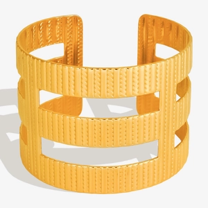 Detailed view of the 18K gold plated cuff bracelet with vertical textures and hollow cutouts