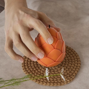 Macro shot of orange dragon egg silicone mold with scale texture and hand for scale