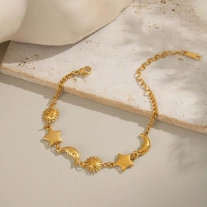 Detailed view of 18K gold plated stainless steel sun moon star charms on a textured base
