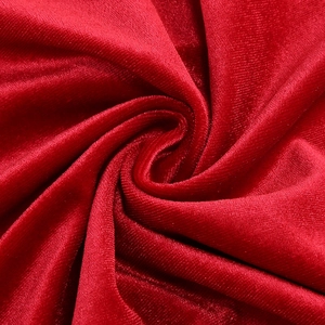 Macro shot of elegant red velvet fabric with rich texture and subtle sheen on the dress