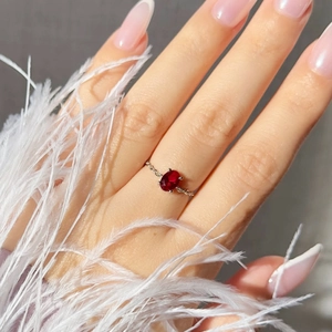 Detailed view of an oval red zircon stone on a silver chain link ring for women