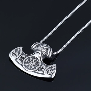 Macro detail of Viking Mjolnir pendant with Vegvísir compass and Norse scroll engraving