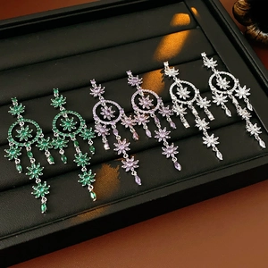 Detail of dreamcatcher tassel earrings with zircons in green, purple, and silver colors
