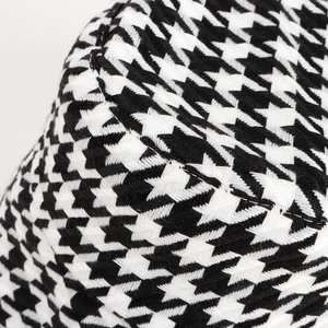 Close-up of houndstooth wool fabric texture and fine stitching on a winter bucket hat