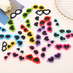Flat lay of colorful mini resin heart and oval sunglasses charms for DIY crafts