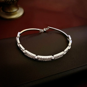Detailed macro view of silver-plated zircon square bracelet with lobster clasp and chain
