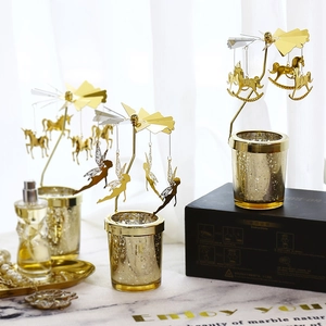 Rotating golden carousel candle holder with fairy charms and speckled glass cup